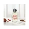 Detail skleněného flakonu mini parfému Rose Oud v jemném zátiší s poupaty růží